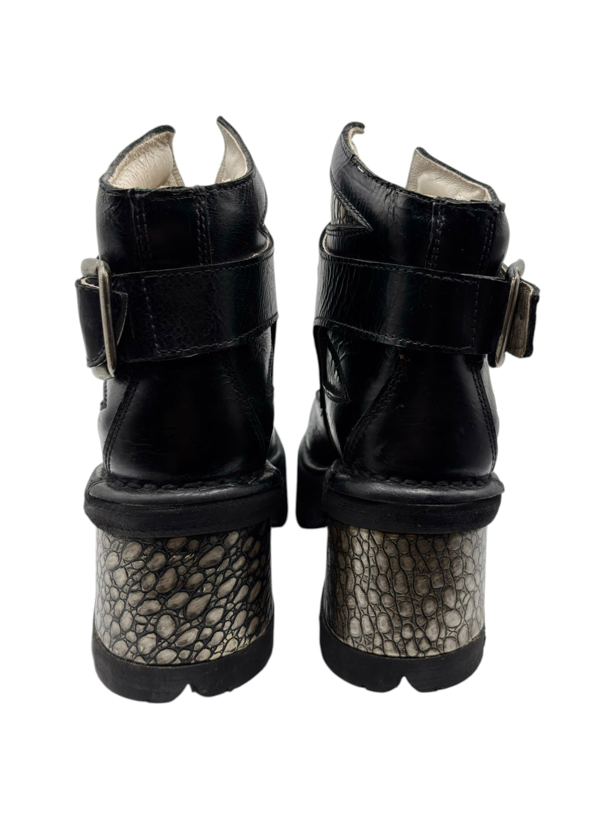 Two black platform ankle boots showing open top lining and textured patterned heel.
