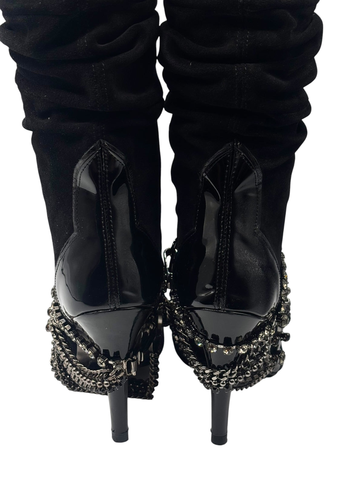 Pair of black knee-high boots with ruched cuffs and decorative chain edging