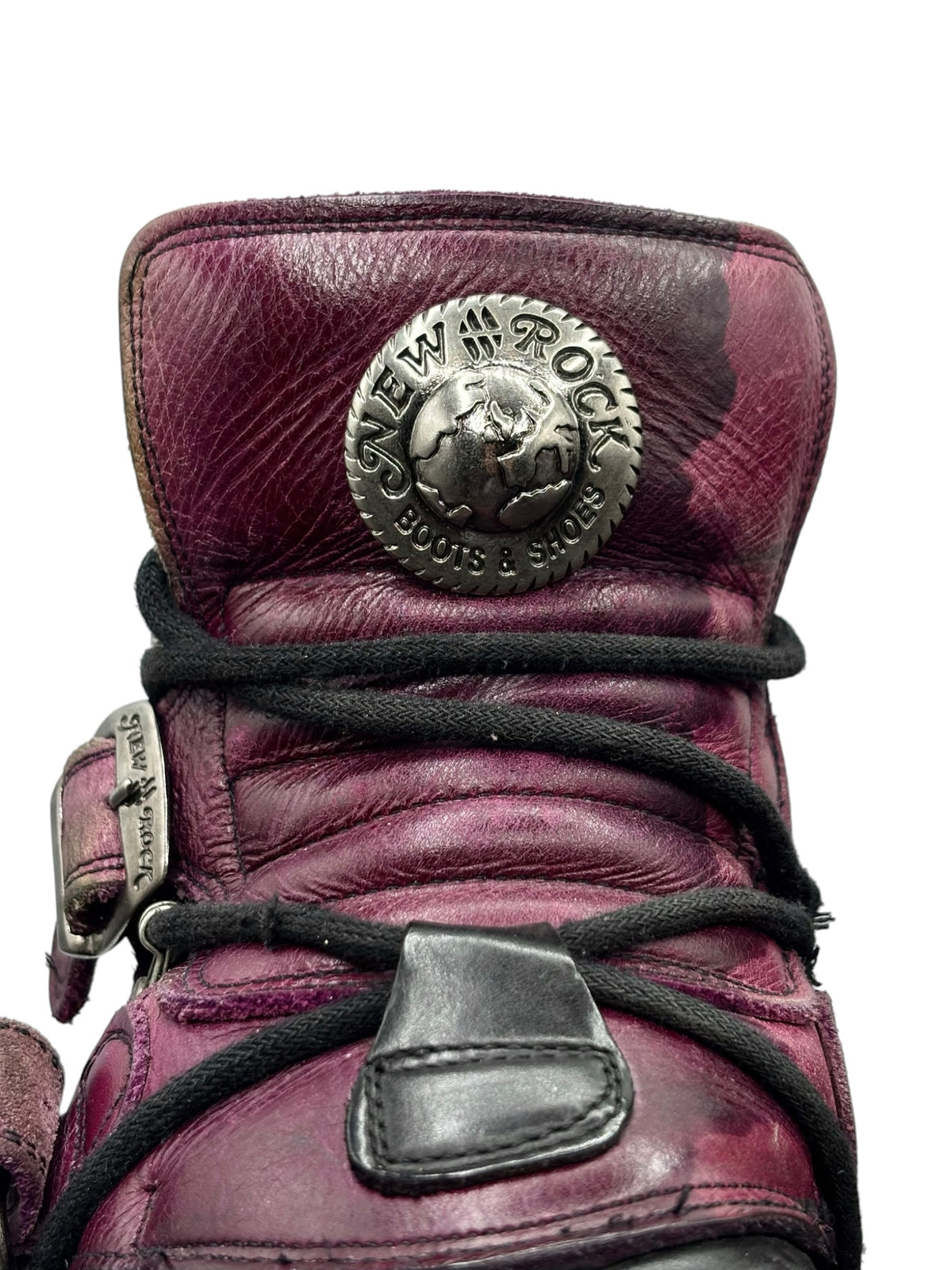 Purple and black platform boots with metal logo patch, laces, and ankle buckle