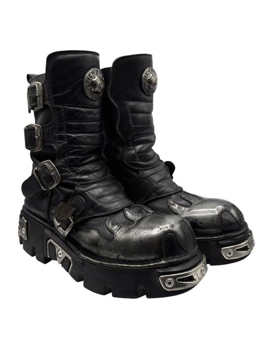 Black leather mid-calf boots with front straps, buckles, and metal heel plates