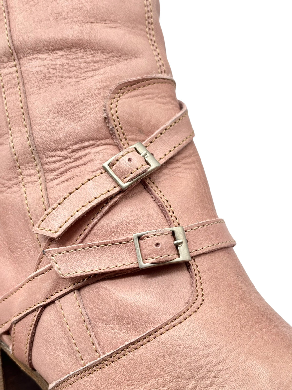 Pink leather boot front close-up with double straps and metal buckle details