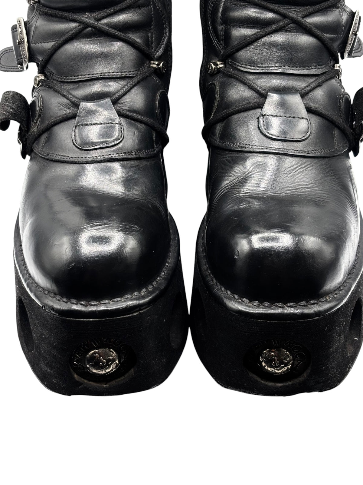 Black platform boots with crisscross laces and square strap overlays