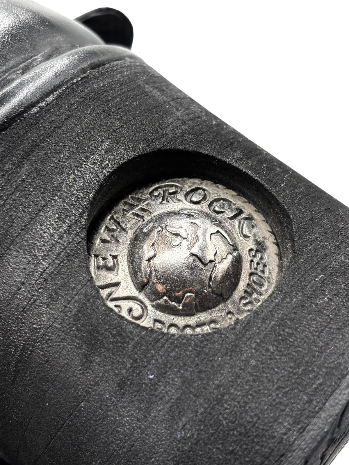 Black boot quarter panel with round silver Rocka logo badge