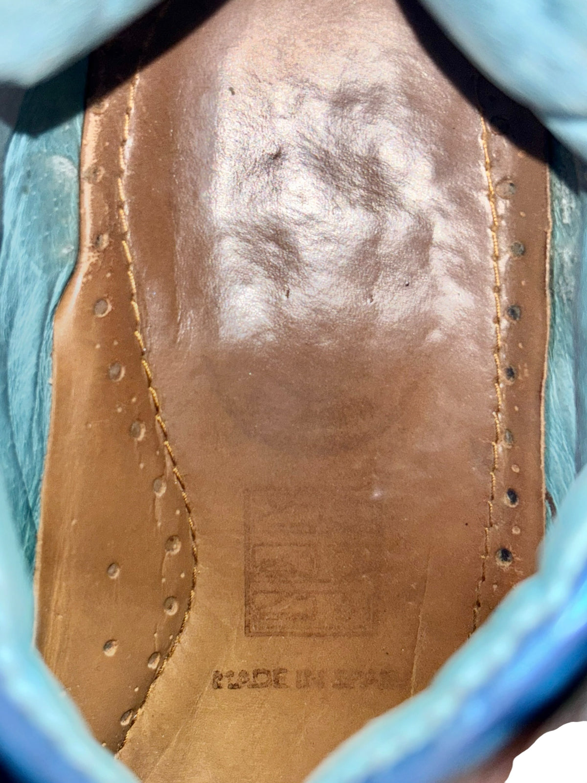 Boot interior in tan leather with stitched edge and textured lining