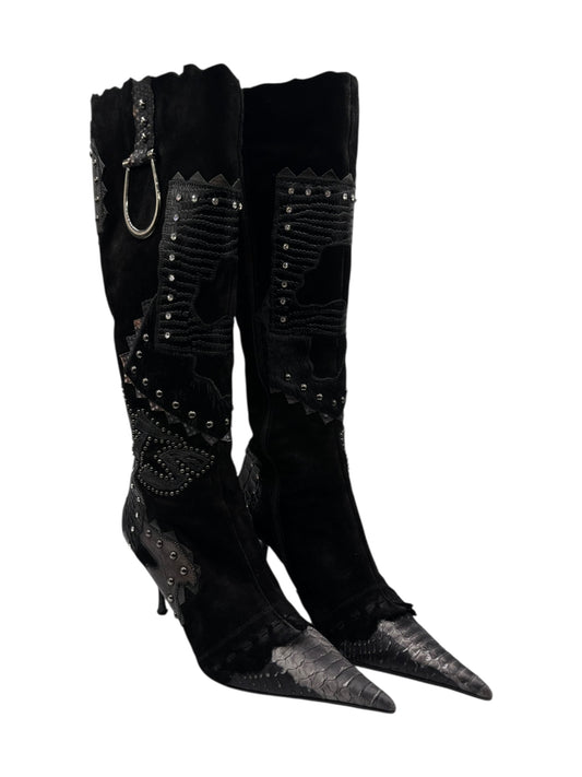 Black pointed-toe knee-high leather boots with side grommet and stud accents
