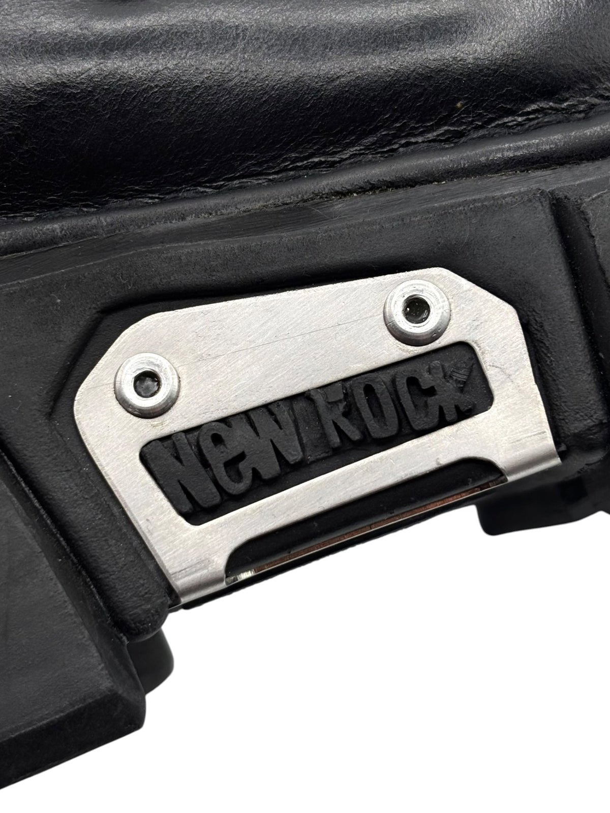 Close-up of New Rock metal logo plate on black platform boot