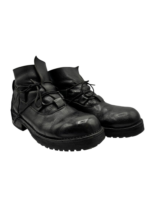 Black lace-up leather boots with textured panels and thick rubber tread sole