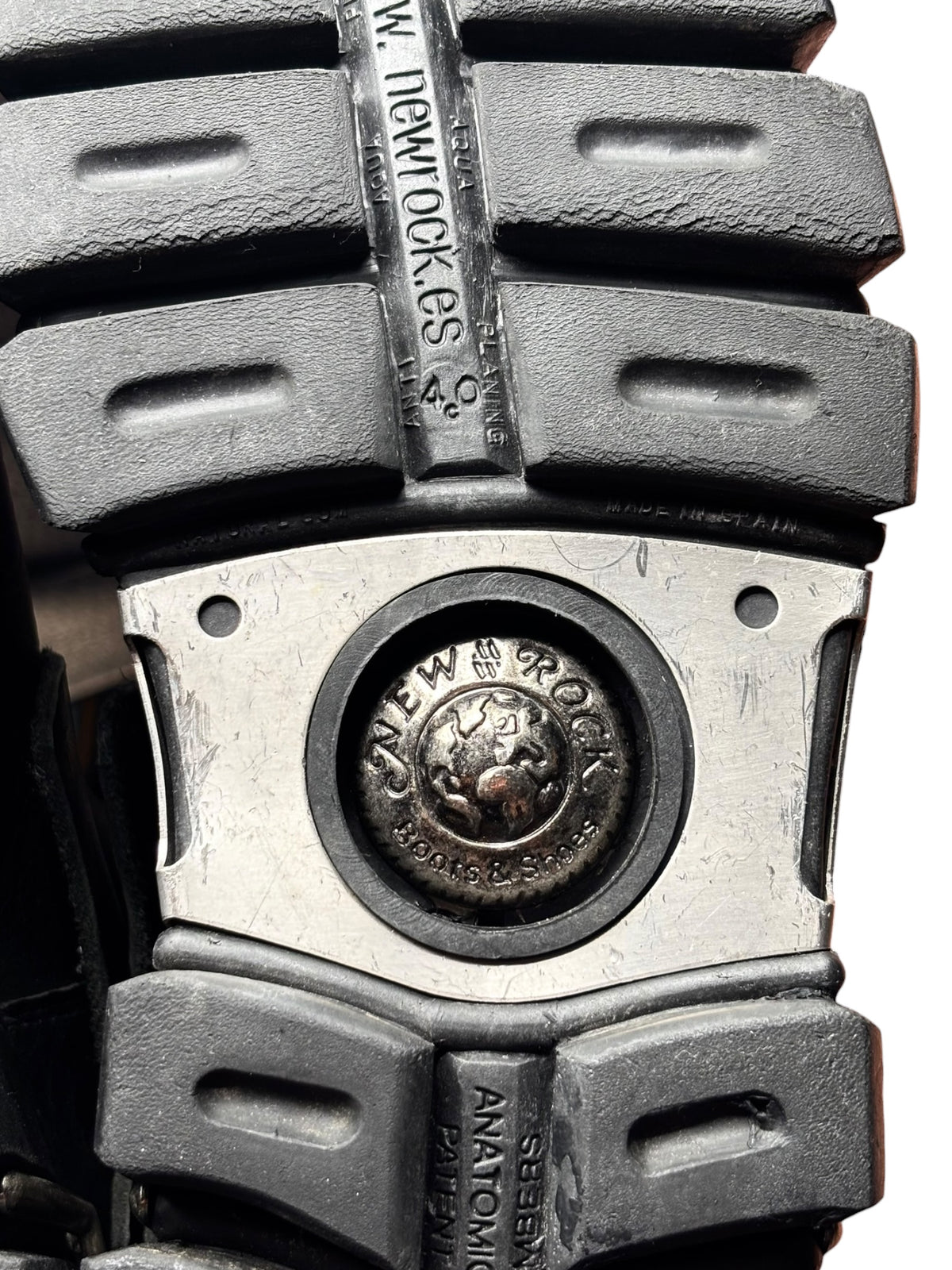 Boot sole detail with metal cap accents and textured rubber tread blocks