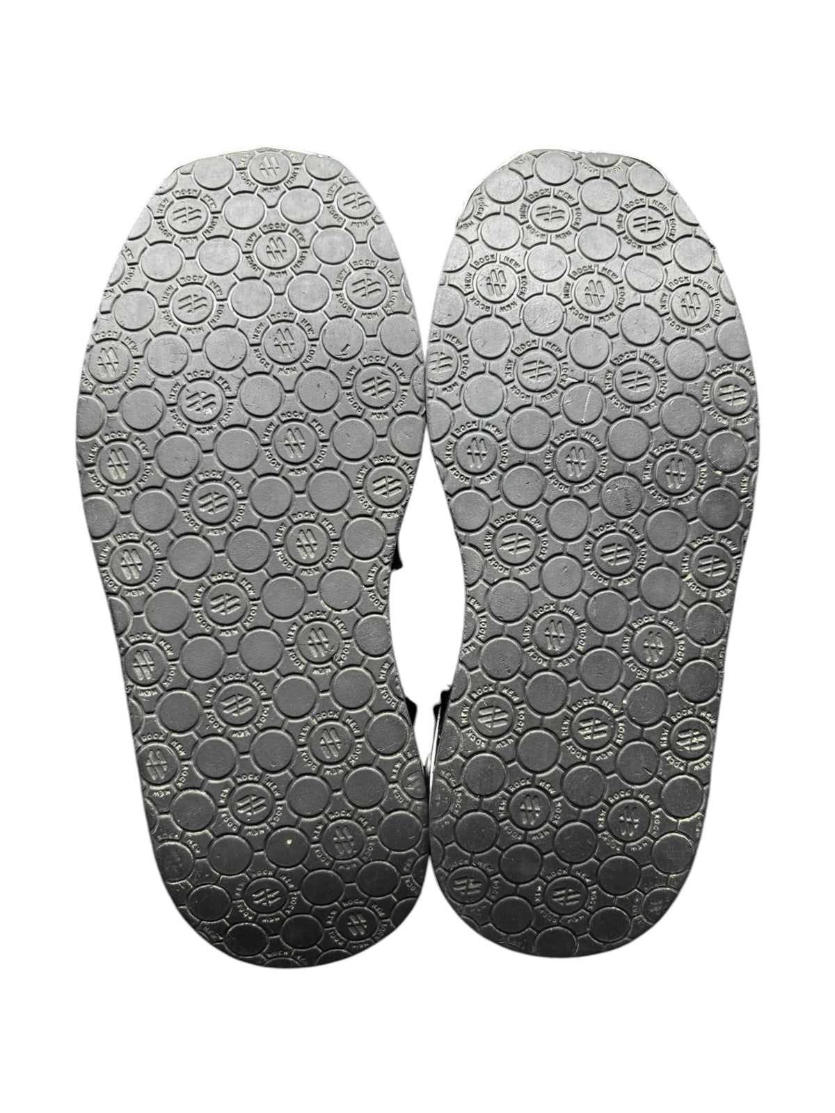 Pair of black platform boot soles with textured tread and circular grip pattern.