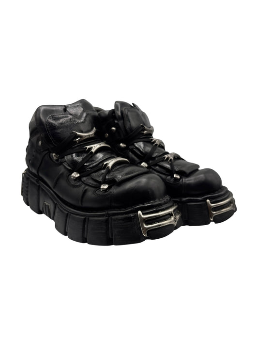 Black leather platform boots with lace-up and metal strap buckles
