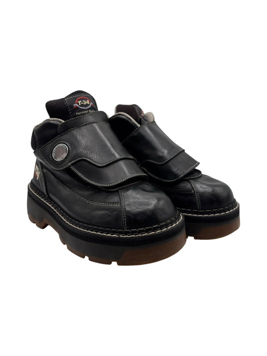 Black platform boots with wide strap detail, chunky sole, and T-34 logo patch