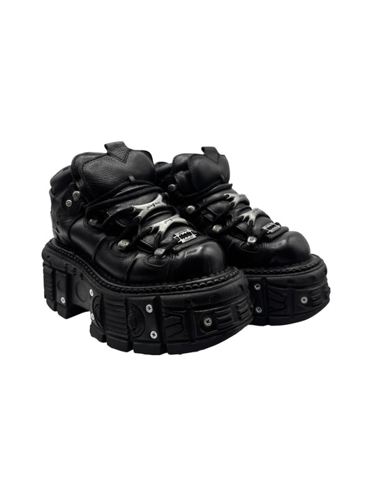 3/4 view of black platform boots with lace-up front and thick protective sole