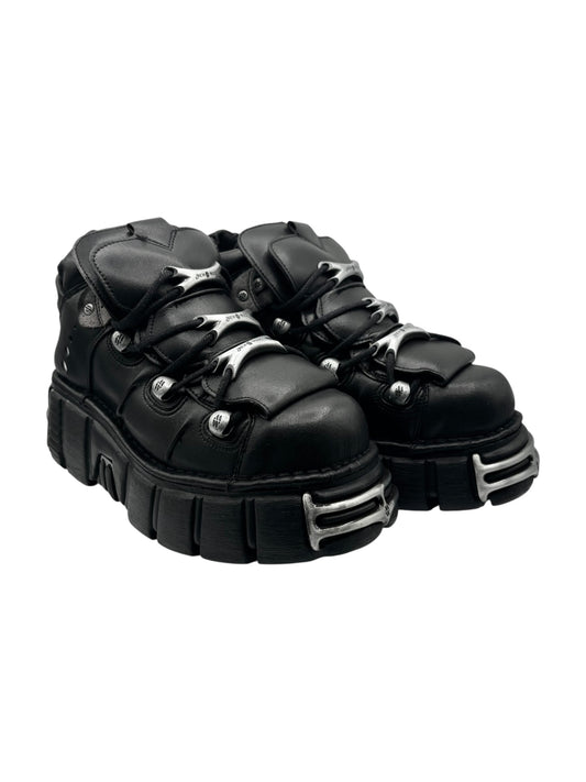 Black platform lace-up boots, side view, with silver eyelets and thick ridged sole