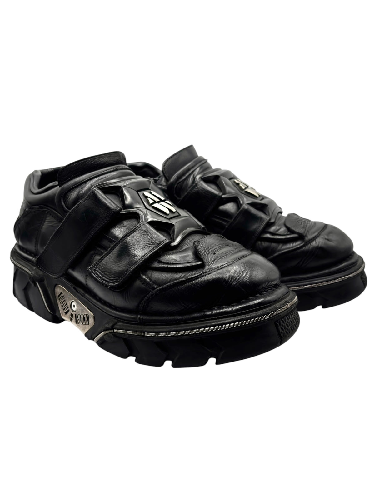 Black leather platform boots with chunky sole and metal logo on straps