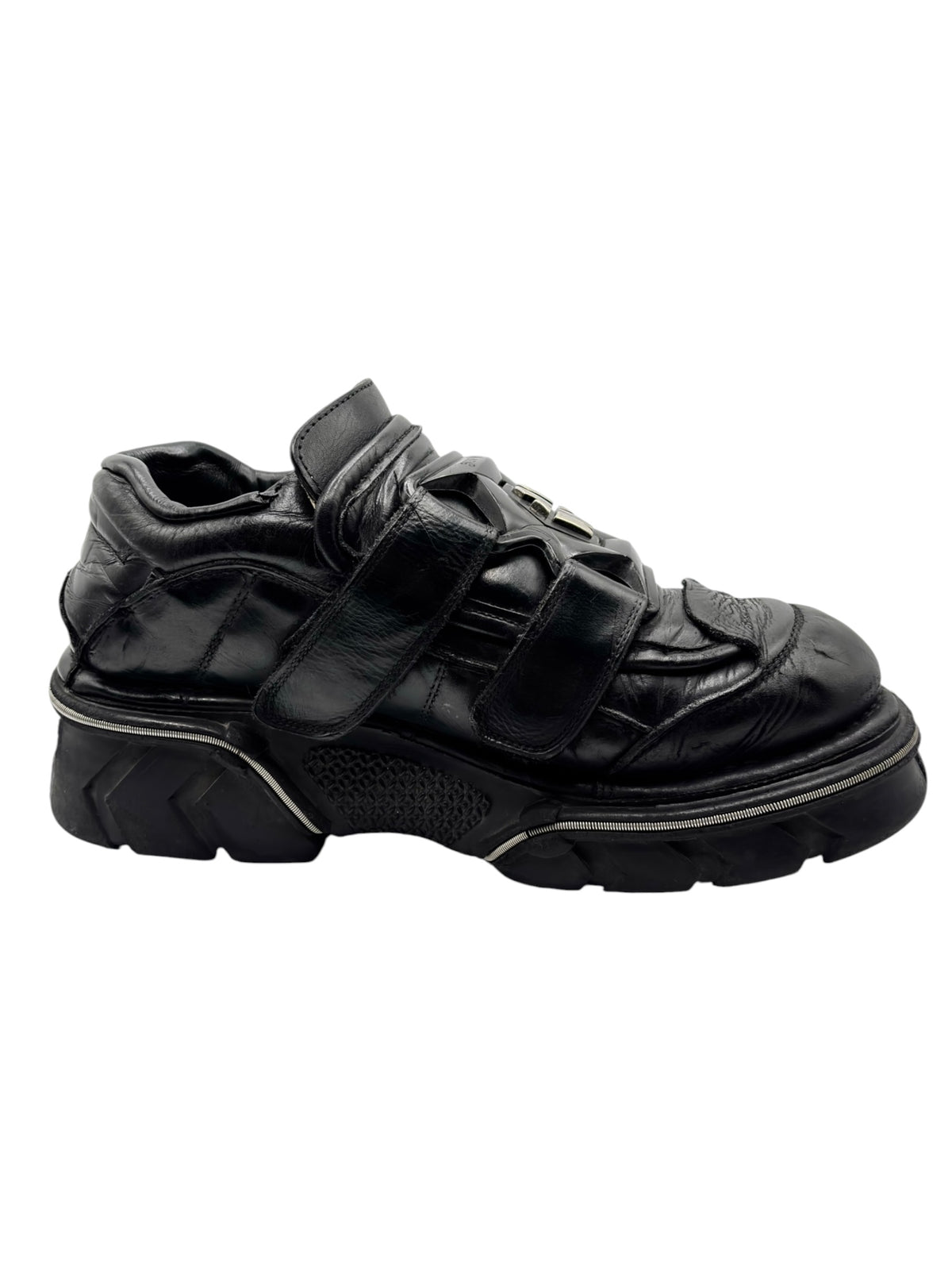 Black leather platform boots with strap closures and chunky treaded sole