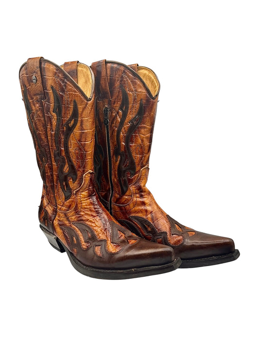 Vintage cowboy boots in brown with orange-toned detailing and curved western stitching.