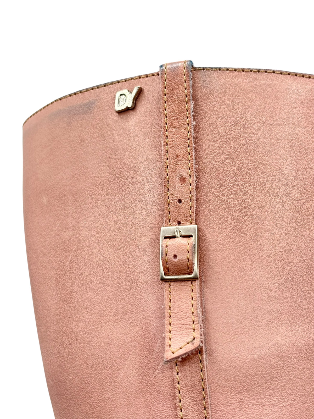 Pink leather boot upper close-up with metal buckle on the side strap