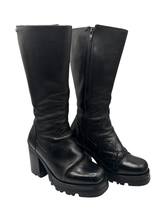 Black knee-high platform boots with block heel and side zipper; scuffed leather.