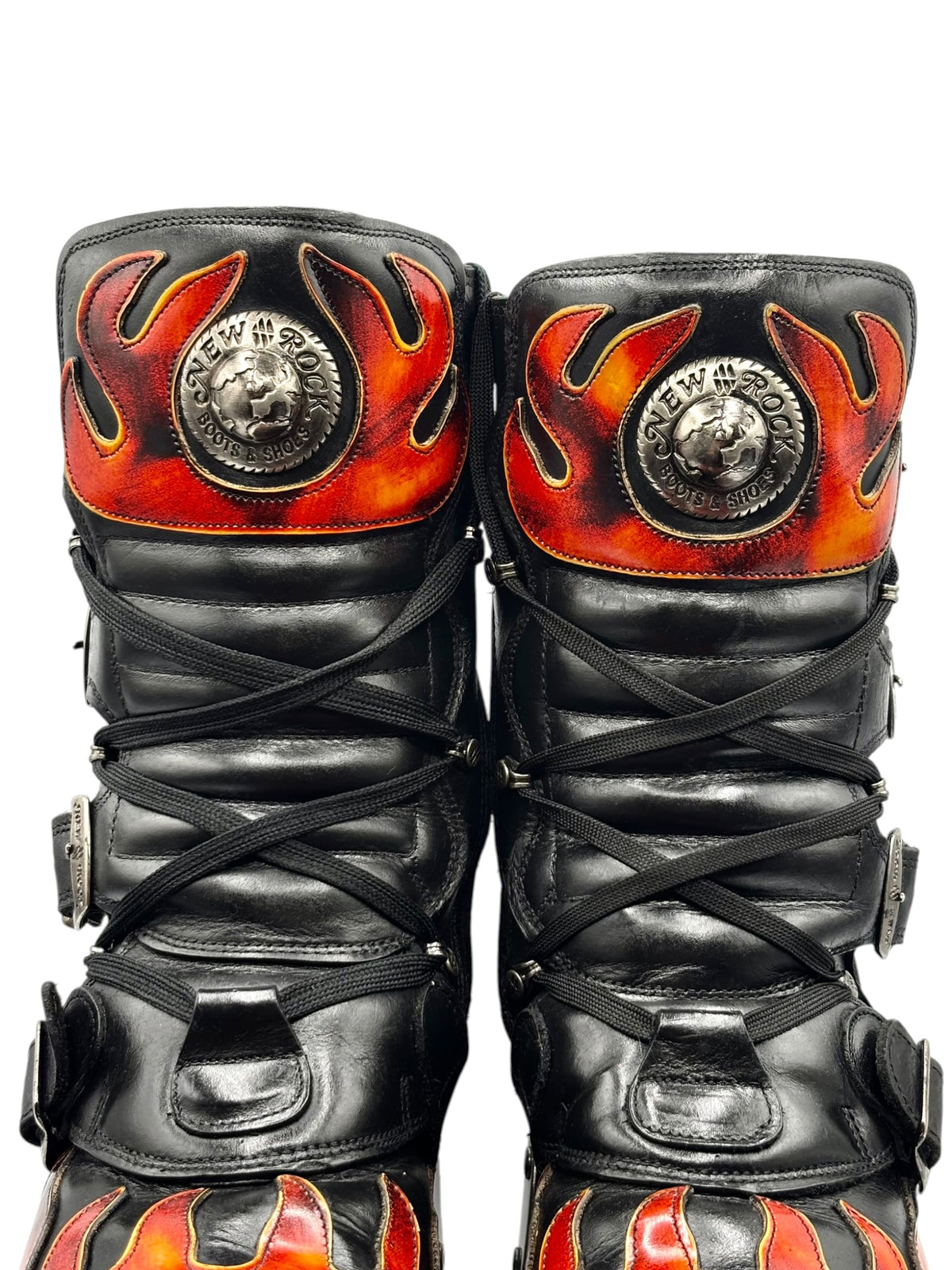 Close-up of black flame platform boot tops with circular “NEW ROCK” medallion.