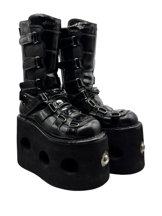 Black platform boots with buckled straps and thick outsole, high ankle shaft.