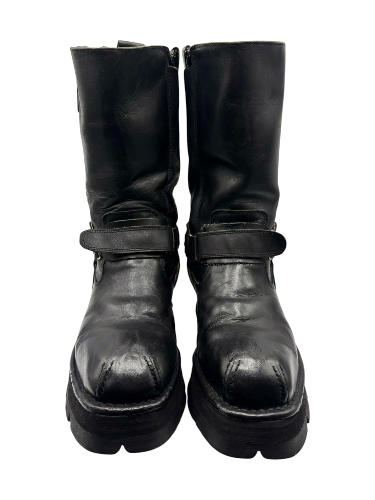 Mid-calf biker boots, black leather with strap buckle and rounded toe.