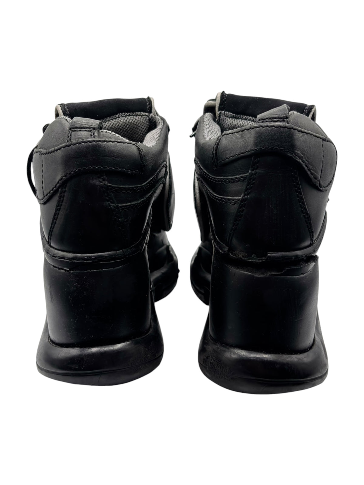 Pair of black platform boots rear view with padded heel and strap loops.