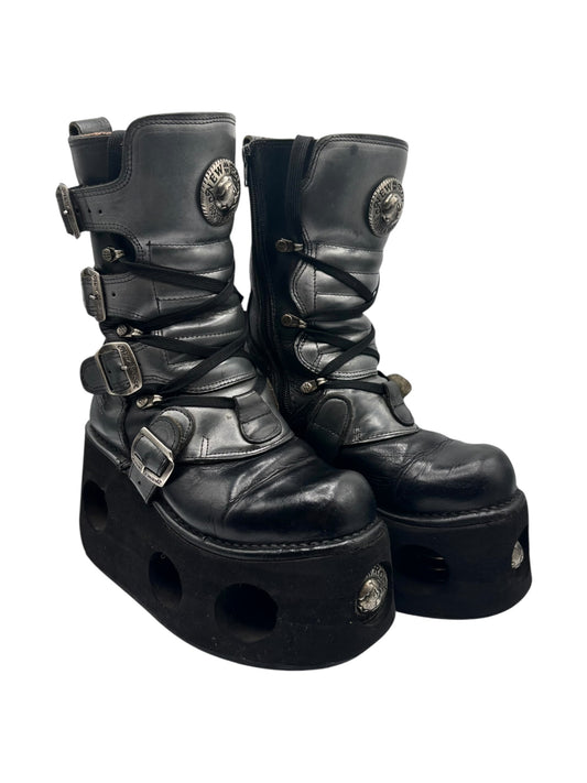 Black mid-calf leather platform boots with straps, buckles, and stud details.
