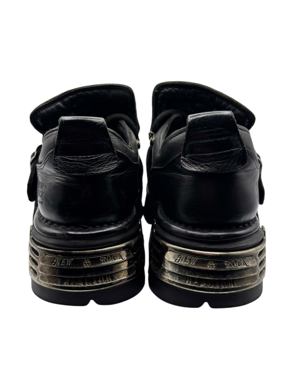 Back view of black platform boots with stacked tread and embossed heel logos.