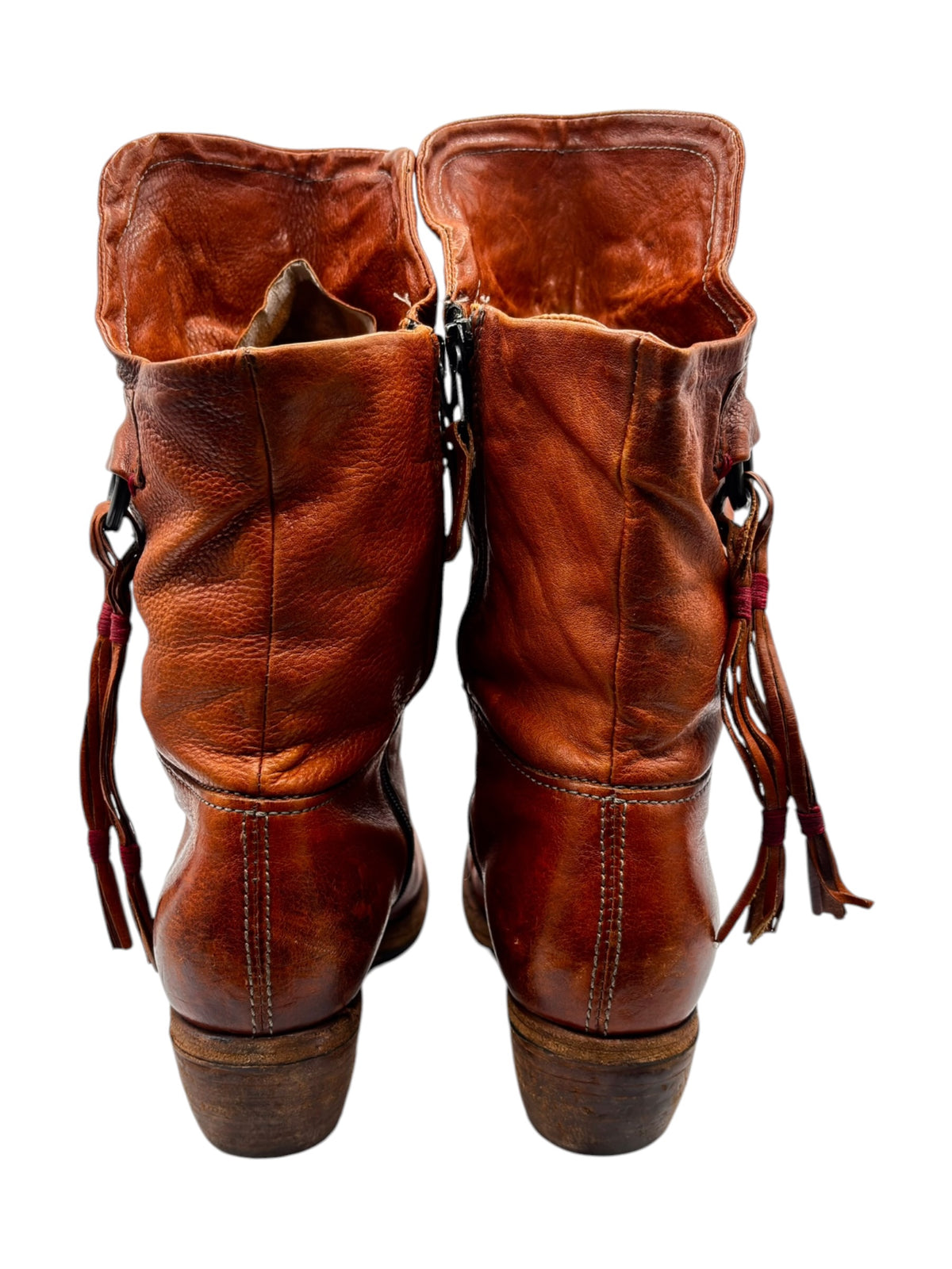 Pair of leather mid-calf boots shown from back with fringe and lace tassels
