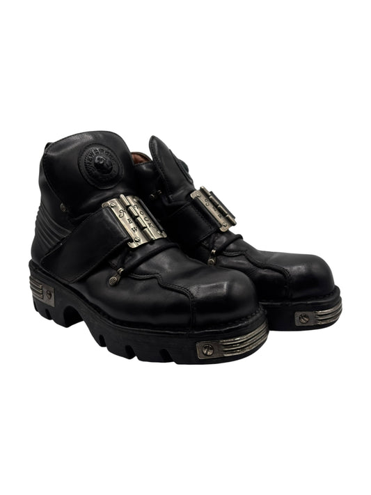 Black leather platform boots with side metal-plate straps and chunky tread sole