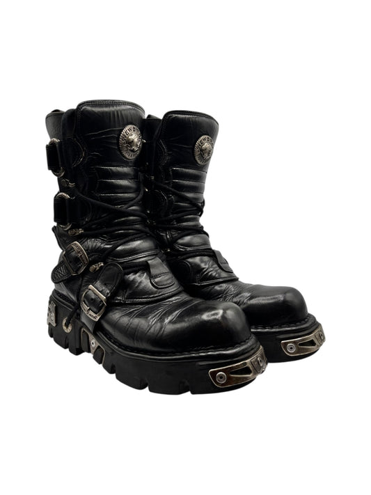 Black mid-calf leather lace-up boots with metal buckle straps and round toe