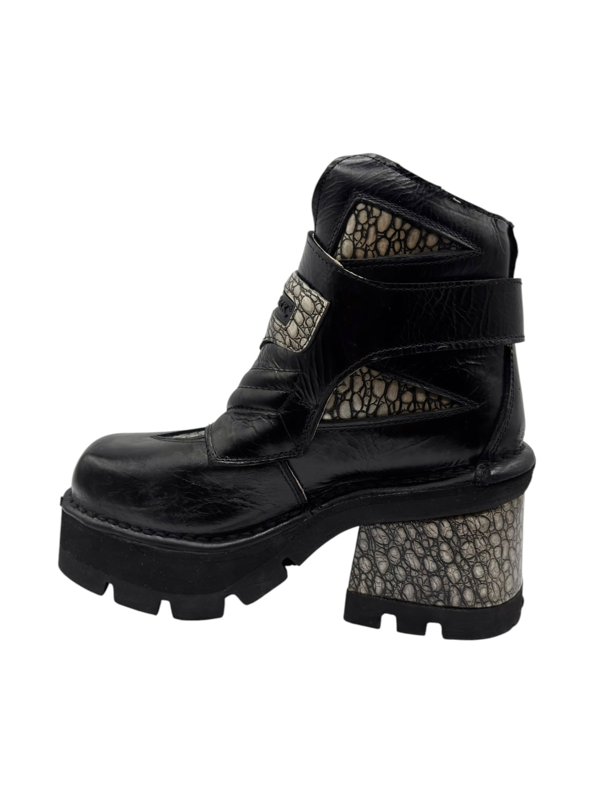 Black leather platform ankle boot with wide strap and textured patterned heel.