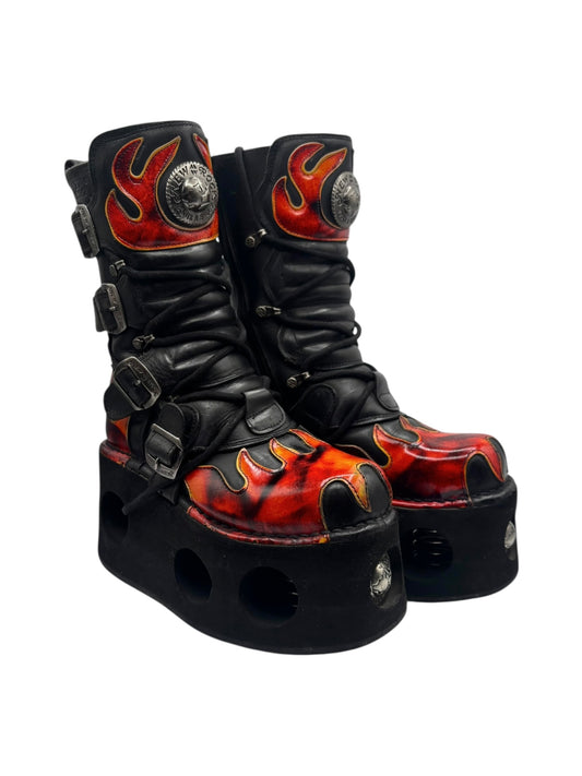 Black flame platform boots with buckle straps and rounded toe holes in the outsole