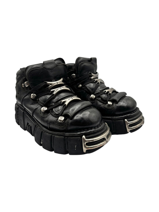 Black platform boots with lace-up front and raised metal heel trim, angled view