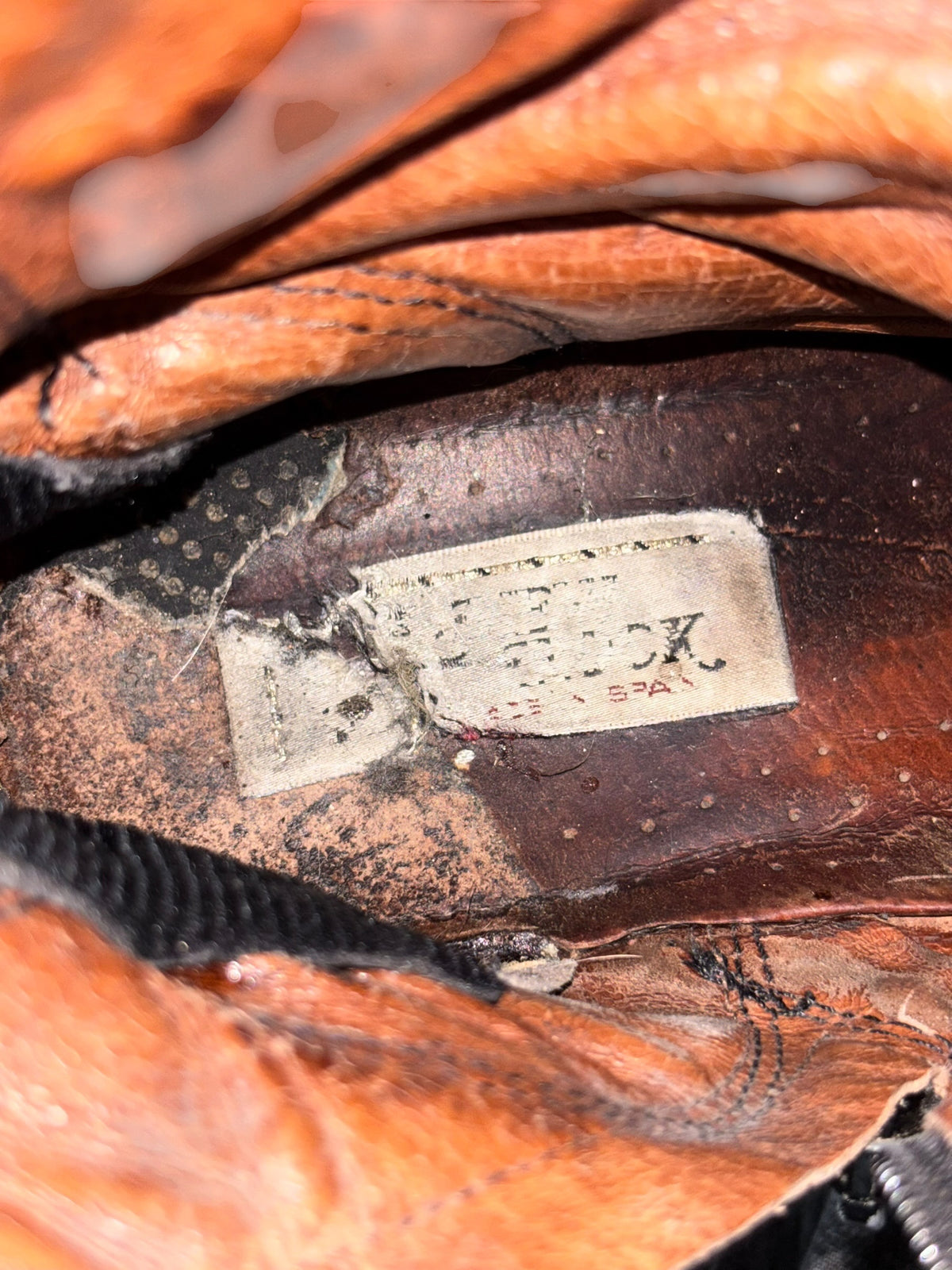 Leather mid-calf boot interior with brand label and stitched lining