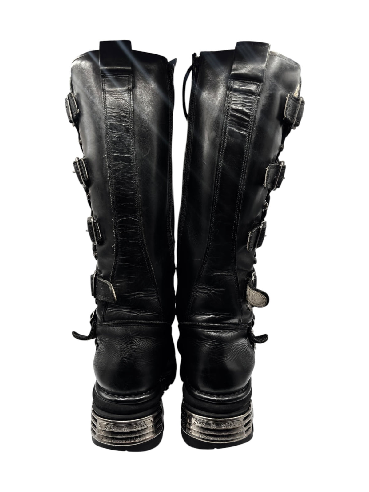 Pair of knee-high black leather boots with side straps and stacked tread soles