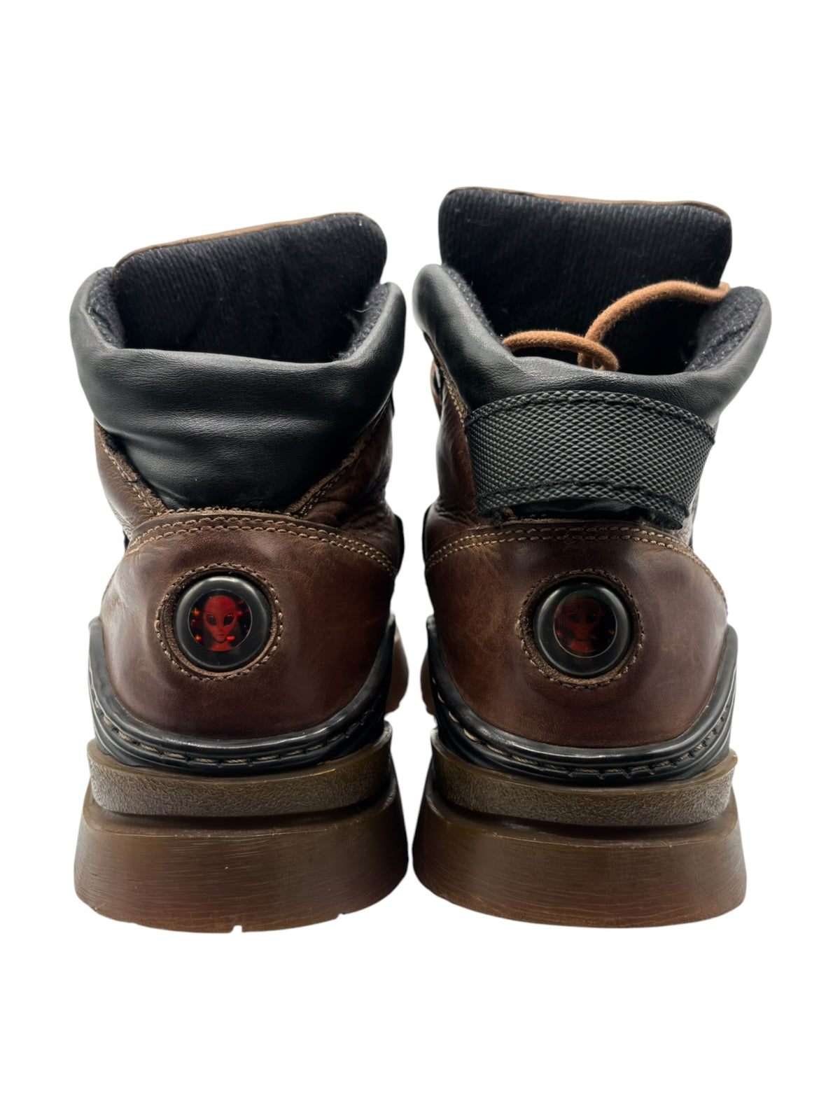 Back view of brown leather boots with black heel panels and round red logo