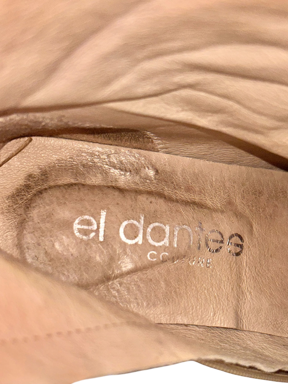 El Dantes beige leather boot lining close-up with embossed logo