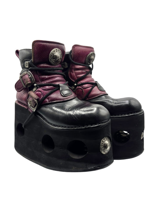 Maroon and black platform boots with side buckles, lace-up ties, and circular cutouts