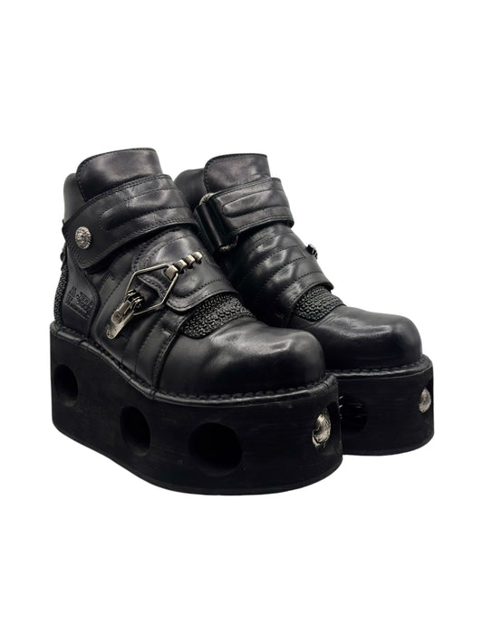 Black leather platform boots with metal clasp strap and stud accents