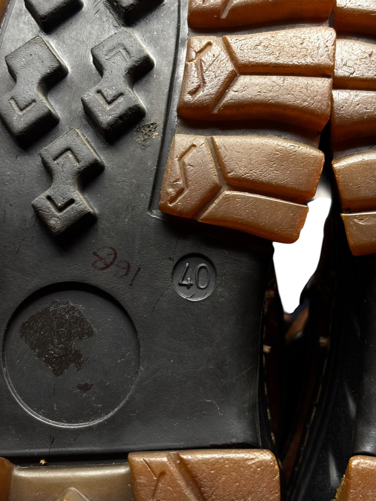 Boot outsole with lug tread, traction blocks, and circular grip details