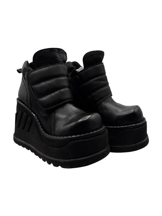 Black leather platform ankle boots with rugged tread sole and side straps.