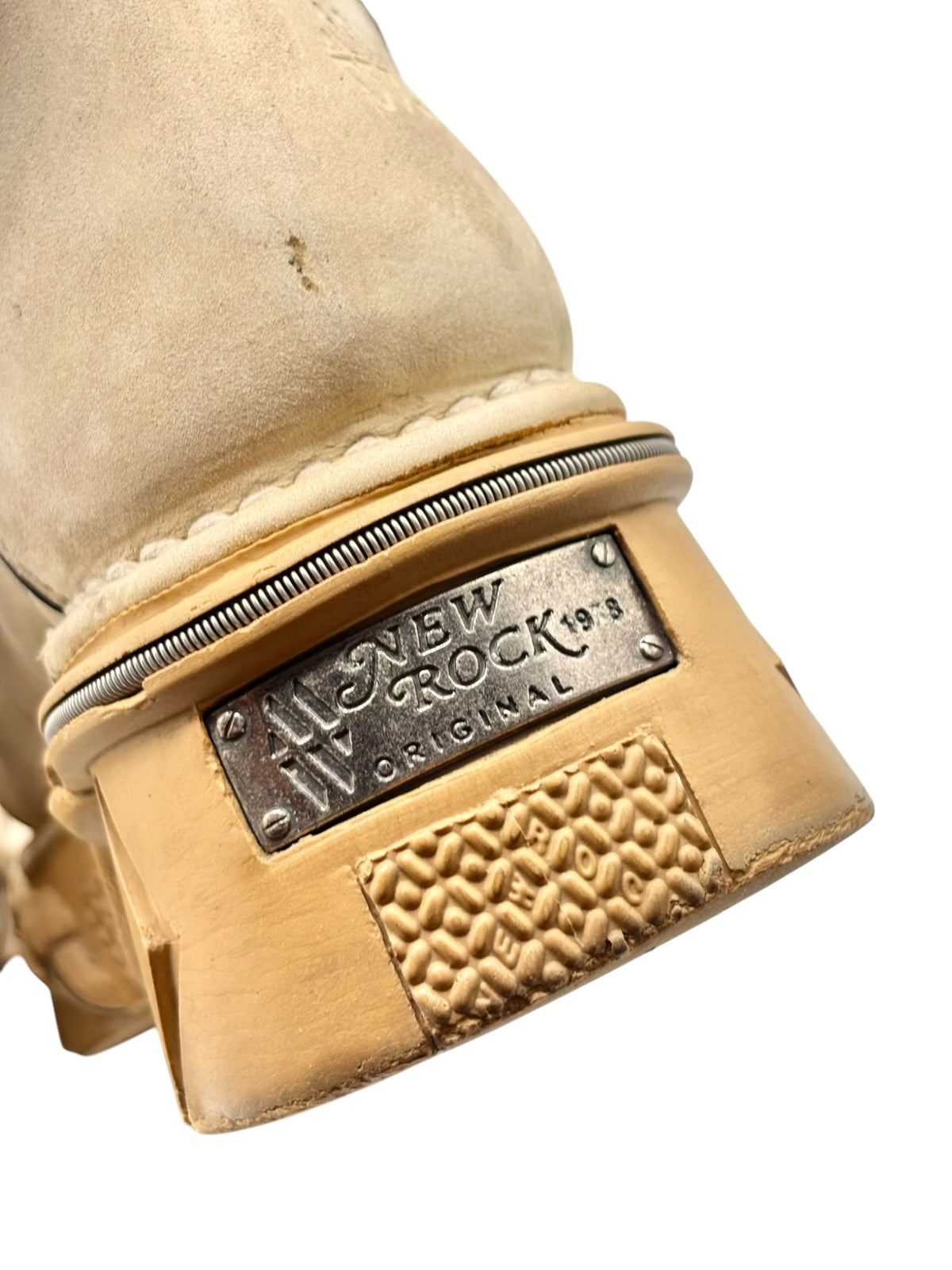 Close-up of beige platform boot heel with “NEW ROCK Original” metal label and tread