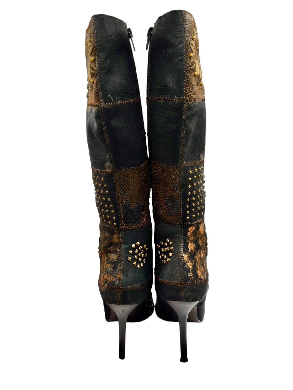 Back view of knee-high patchwork boots with stiletto heels and studded medallions.
