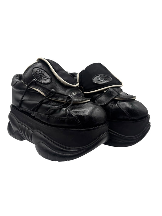 Black chunky platform boots with straps, buckles, and cream-edged lining