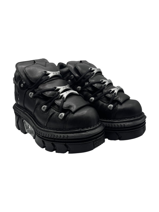 Black lace-up platform boots with chunky lug sole, metal eyelets and top buckles