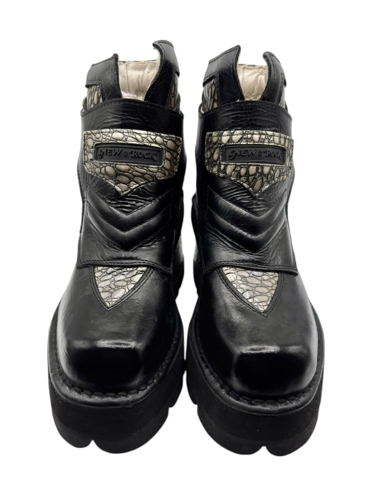Pair of black leather ankle platform heels with beige scale-pattern panels and buckles.