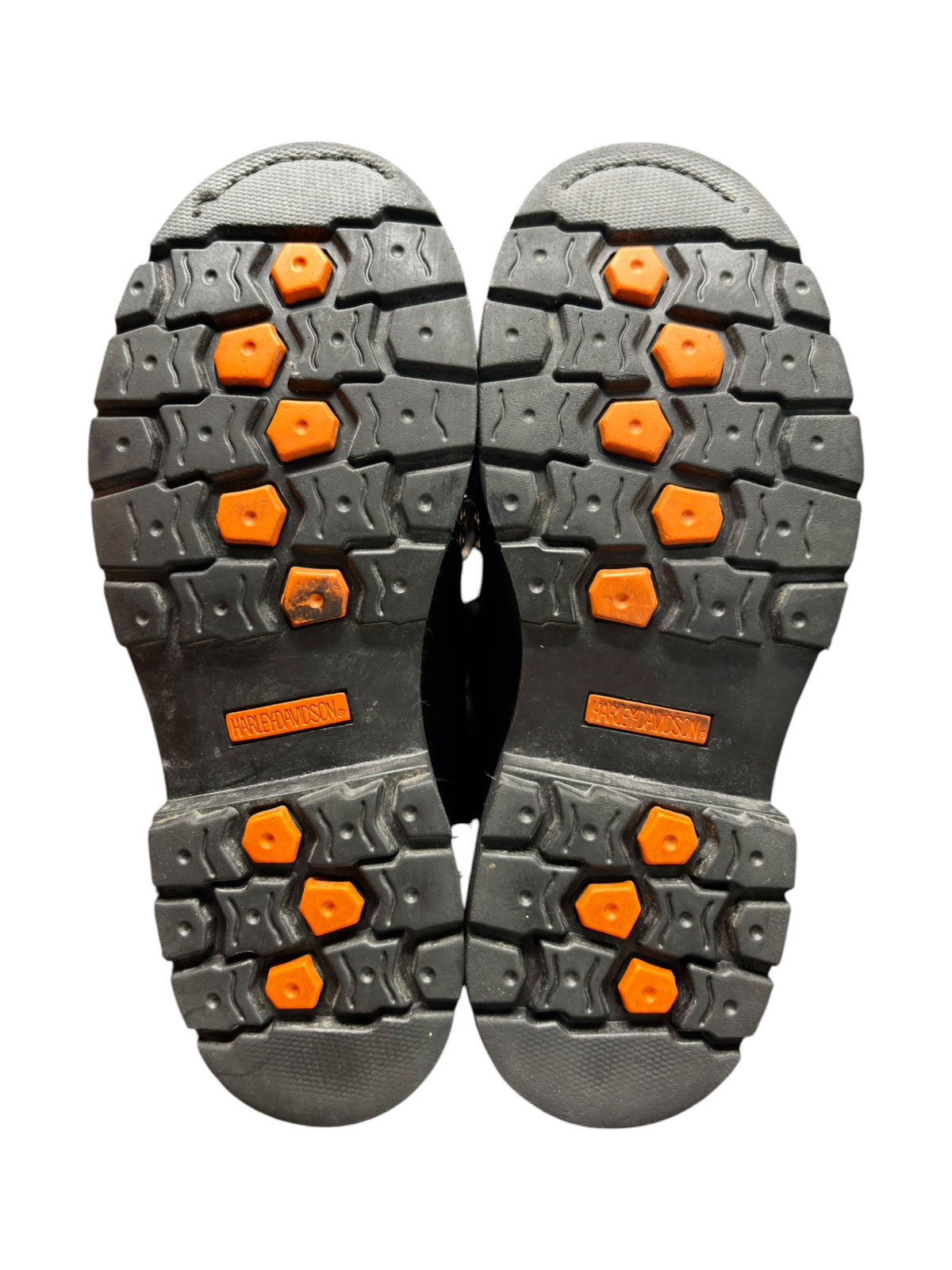 Pair of black boot outsoles with orange traction knobs and tread pattern