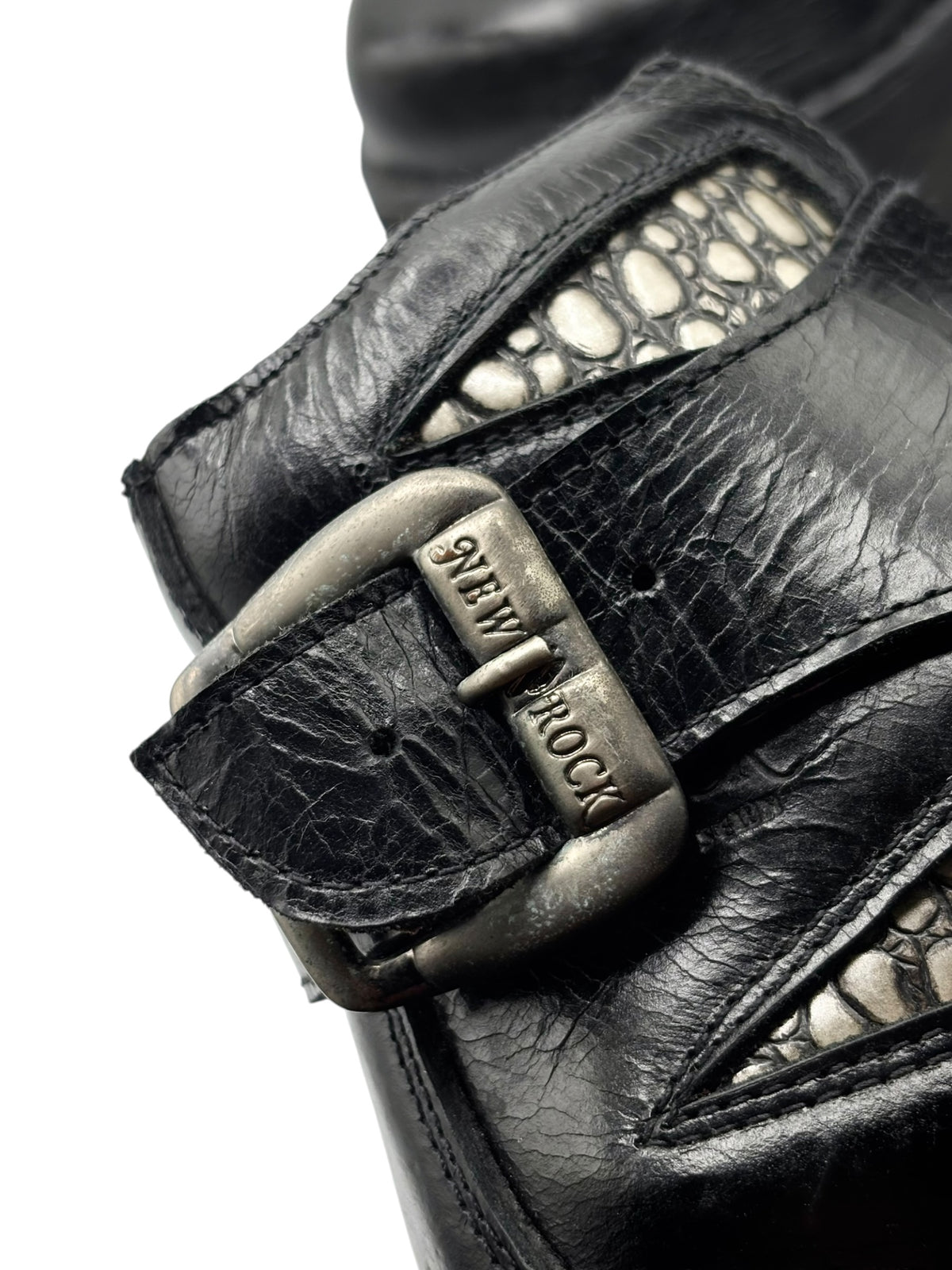 Black leather platform heel with buckle strap and textured patterned side panel.