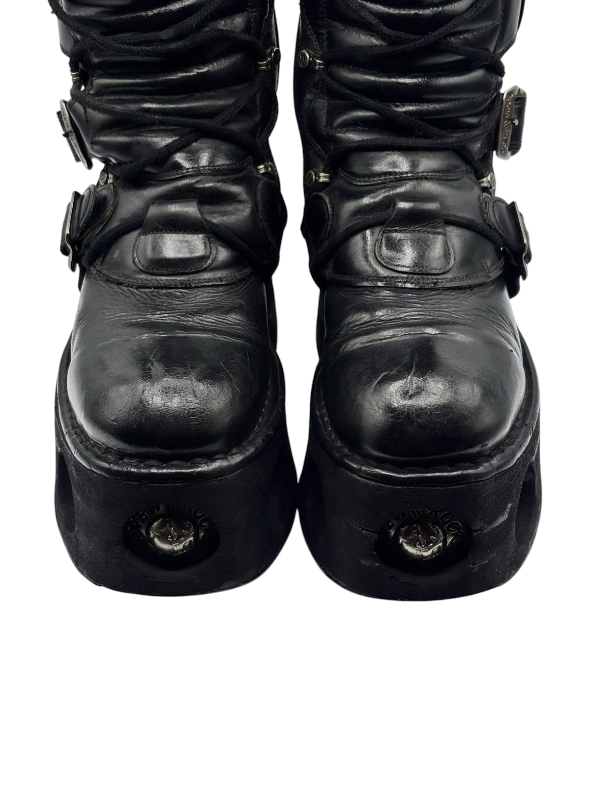 Black mid-calf platform boots with buckles and round emblem on front